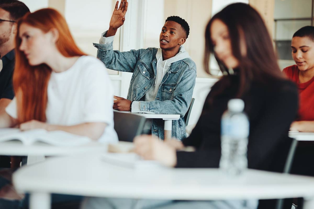 Student raising his hand in a classroom